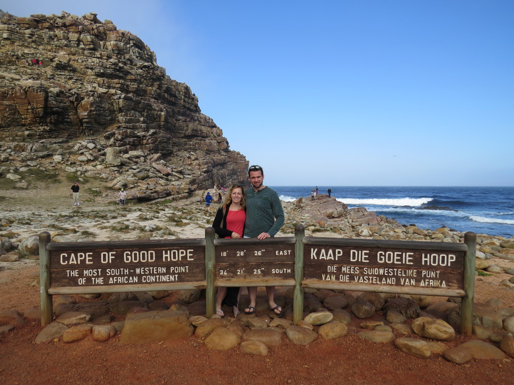 Reizigers bij het bord Cape of Good Hope aan de kust van Zuid-Afrika tijdens de Tuinroute groepsrondreis.