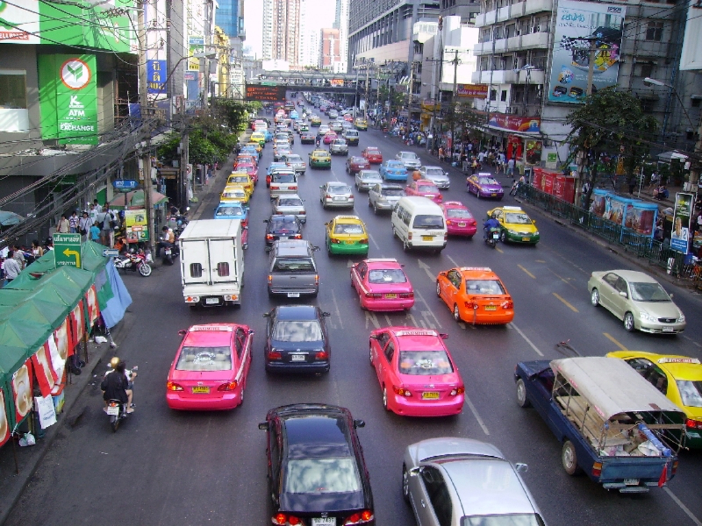Hoofdstraat met lokale winkels en verkeer in Thailand tijdens de familiereis Thailand Chill & Adventure.