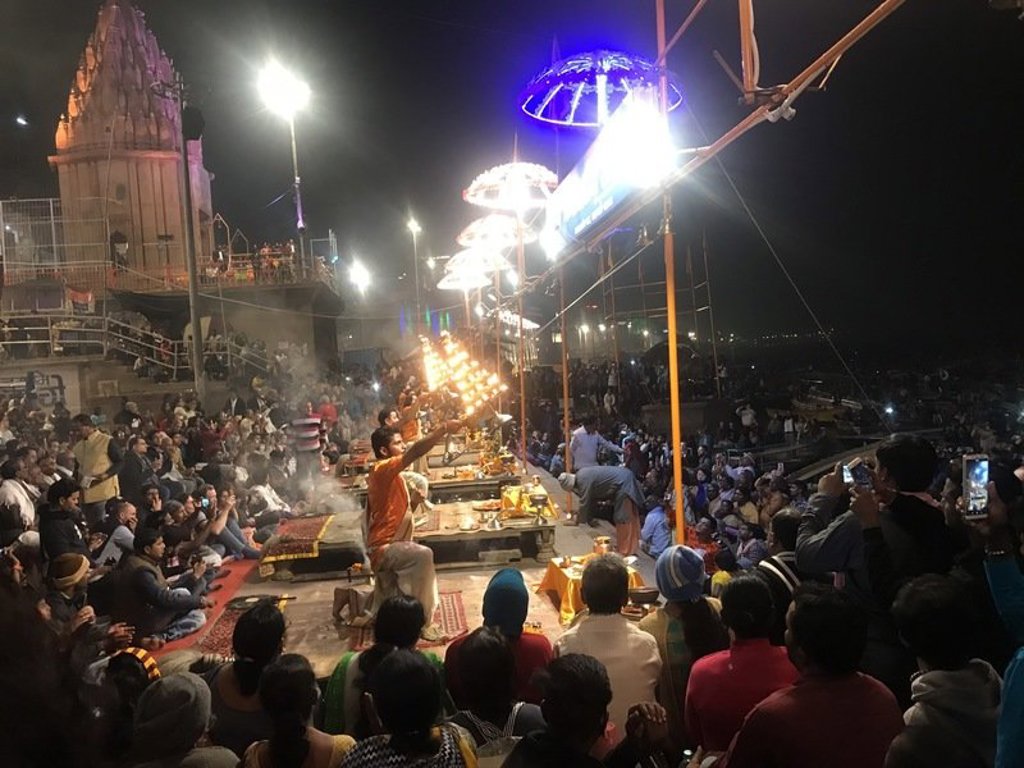 Avondceremonie aan de Ganges in Varanasi met brandende olielampen, priesters en een grote menigte.