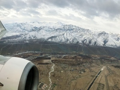 Vliegtuigraam met zicht op besneeuwde Himalaya-bergen en vallei in Ladakh tijdens de Route Spiti & Ladakh.