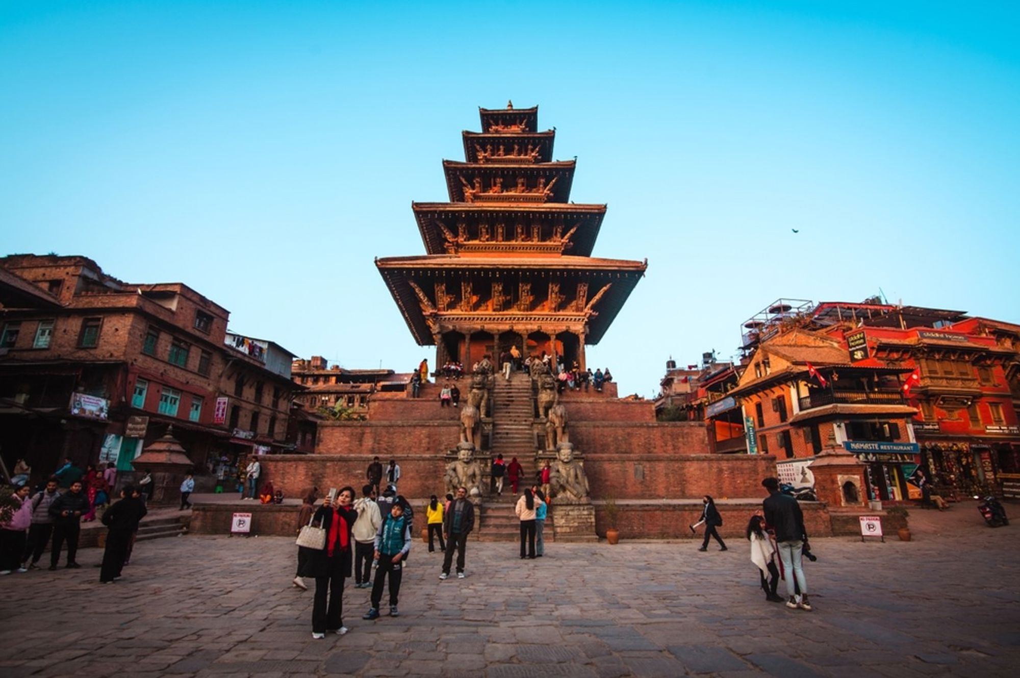 Nyatapola-tempel op Taumadhi-plein in Bhaktapur, Nepal, met bezoekers op de trappen.