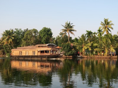 Woonboot op de backwaters van Kerala, omringd door palmbomen, tijdens de Route Zuid-India rondreis.