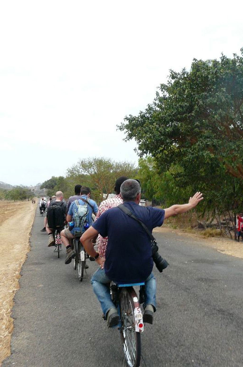 Fietstocht met groep reizigers over een landelijke weg tijdens groepsrondreis Zambia, Malawi en Tanzania.