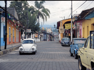 Straat met kleurrijke gevels en klassieke auto’s in San Cristóbal de las Casas, Route Mexico.