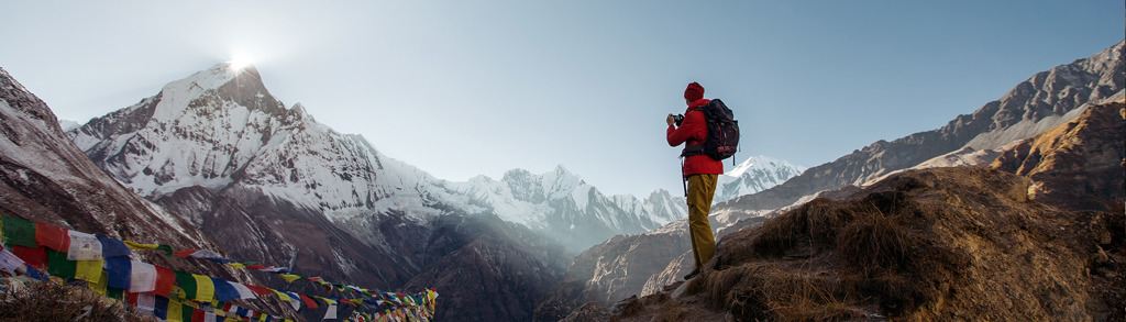 Wandelaar met rugzak kijkt uit over de Himalaya bij Annapurna Base Camp, Nepal.