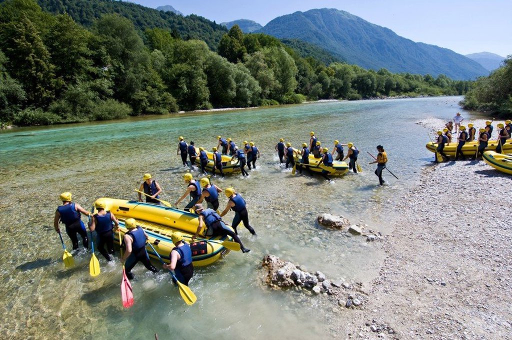 Groepsrondreis Slovenië: kanoën op een meer met berglandschap op de achtergrond.