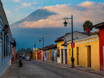 Kleurrijke straat in Antigua, Guatemala, met de vulkaan Agua op de achtergrond.