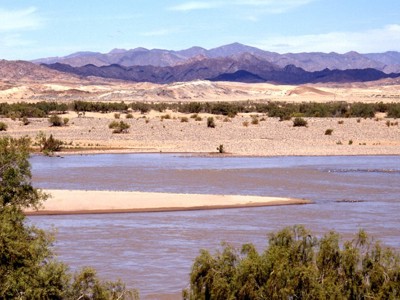 Rivier met zandbanken en bergen in de verte tijdens groepsrondreis Zuidelijk Afrika, route Victoria Falls–Kaapstad.