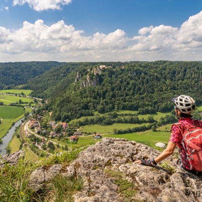 Fietser geniet van uitzicht over de Donauvallei tijdens fietsvakantie langs de Donau in Oostenrijk.