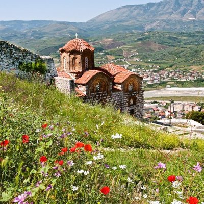 Uitzicht op de Albanese Alpen met een wandelpad door groene bergen en mistige bergtoppen.