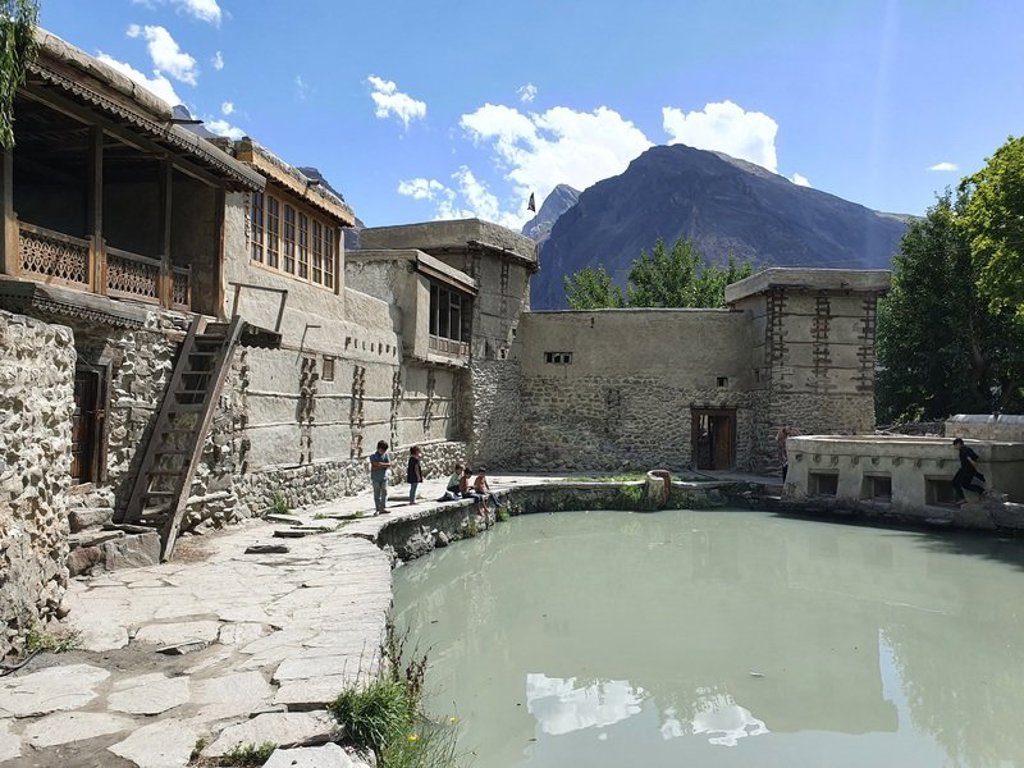 Hangbrug over een rivier in Baltistan met besneeuwde bergtoppen op de achtergrond, Pakistan.