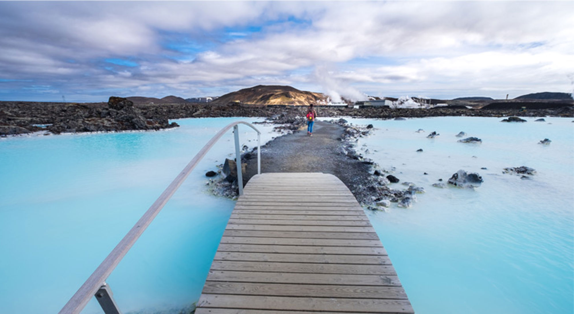 Houten loopbrug naar de Blue Lagoon met helderblauw geothermisch water in IJsland.