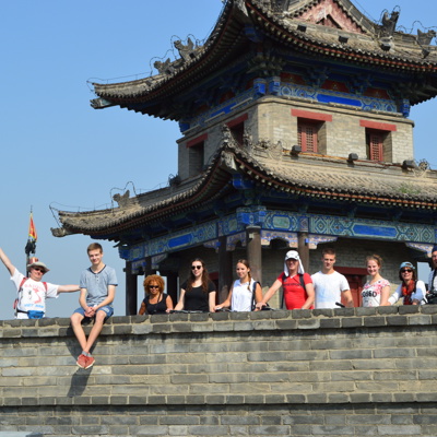 Reizigers op de Chinese Muur bij een traditionele wachttoren tijdens een familiereis China.