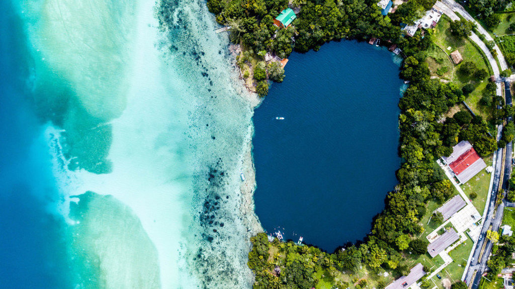 Laguna Bacalar met helderblauw water en groene oever, tijdens een groepsrondreis Mexico.