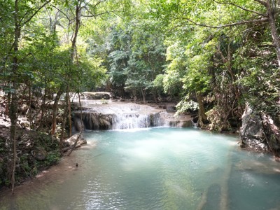 Waterval met turquoise natuurzwembad in het groene regenwoud van Thailand.