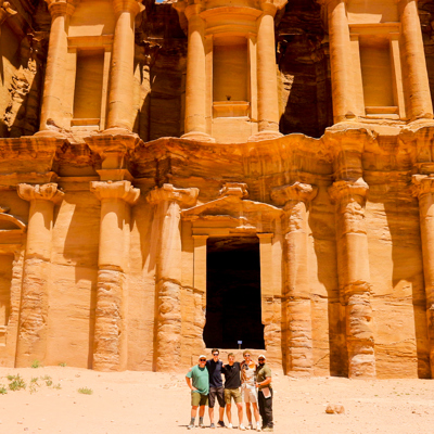 Groep reizigers bij het rotsgraf Ad Deir in Petra, Jordanië.