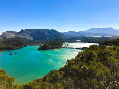 Uitzicht op een turquoise stuwmeer met brug en bergen tijdens de wandelroute in Andalusië, Spanje.