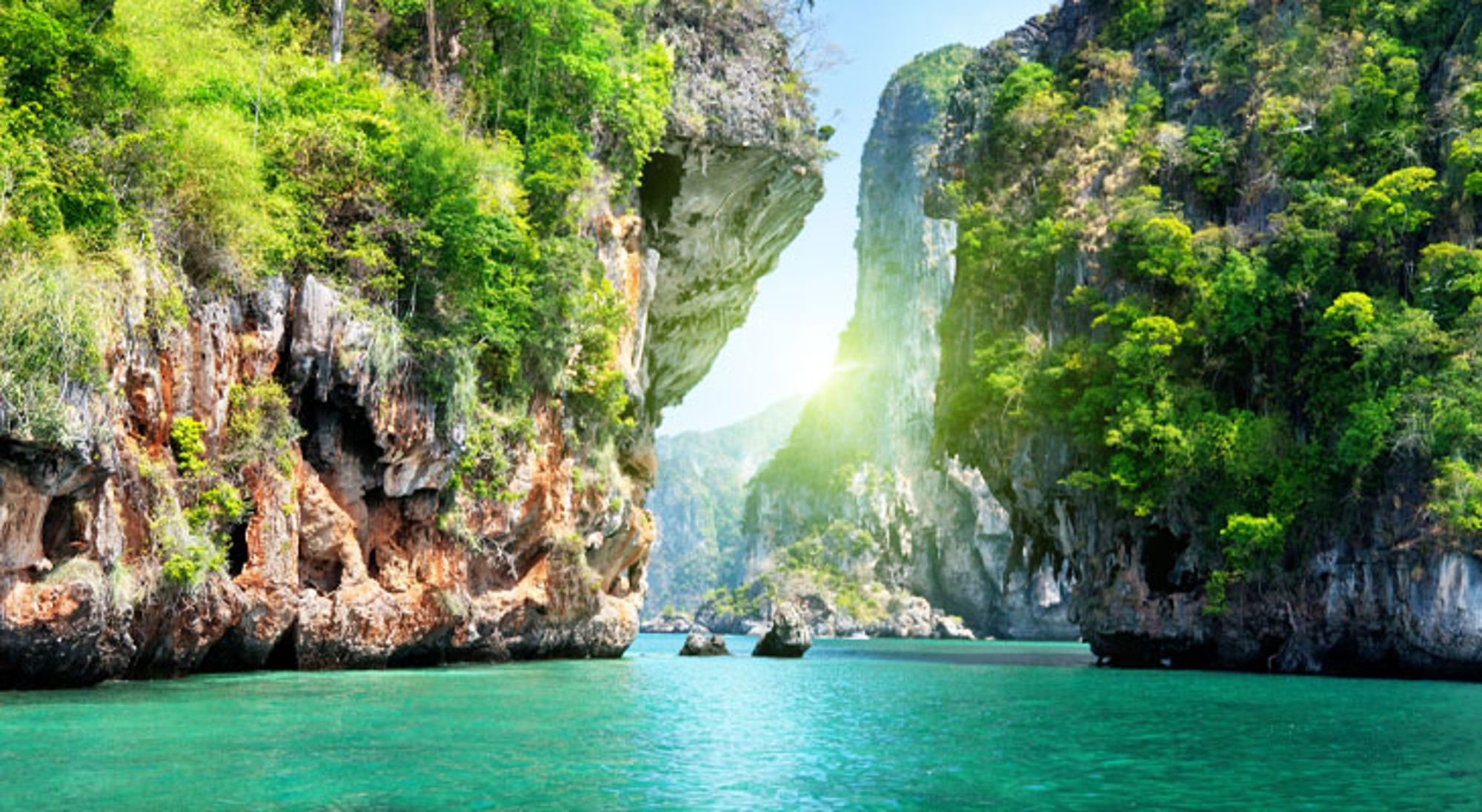 Groene kalksteenkliffen en turquoise zee in Thailand.