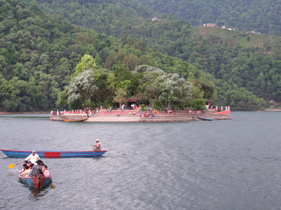 Bootjes op Phewa Lake met een tempel op een klein eiland bij Pokhara, Nepal.