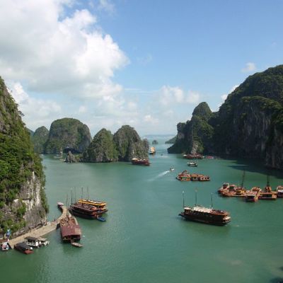Uitzicht over Halong Bay in Vietnam met kalkstenen rotsen en traditionele boten op turquoise water.