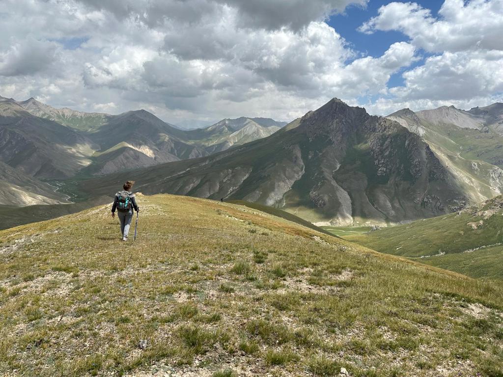 Groepsrondreis Kirgistan: wandelaar met rugzak in berglandschap langs de Zijderoute.