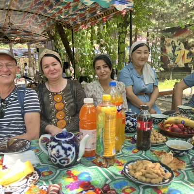 Groepsrondreis Zijderoute: samen aan tafel met lokale gastvrijheid, thee en hapjes in de schaduw.