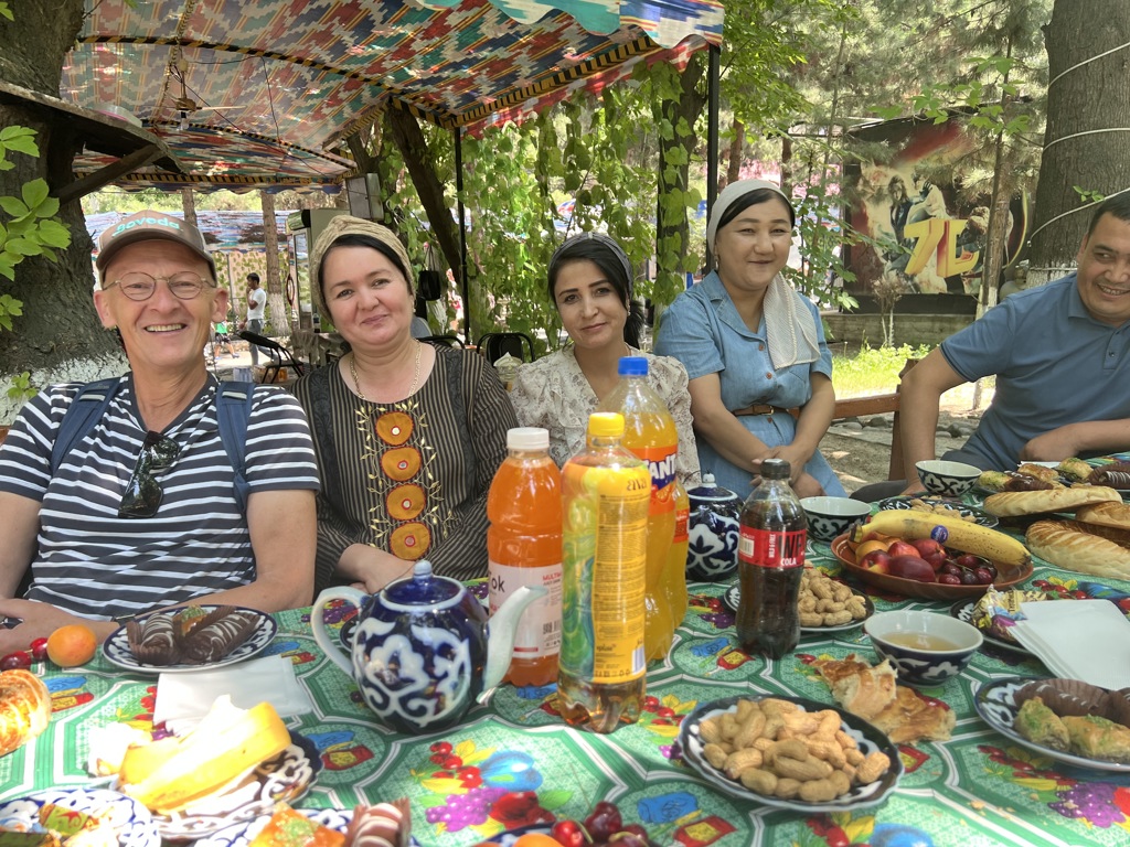 Groepsrondreis Zijderoute: samen aan tafel met lokale gastvrijheid, thee en hapjes in de schaduw.