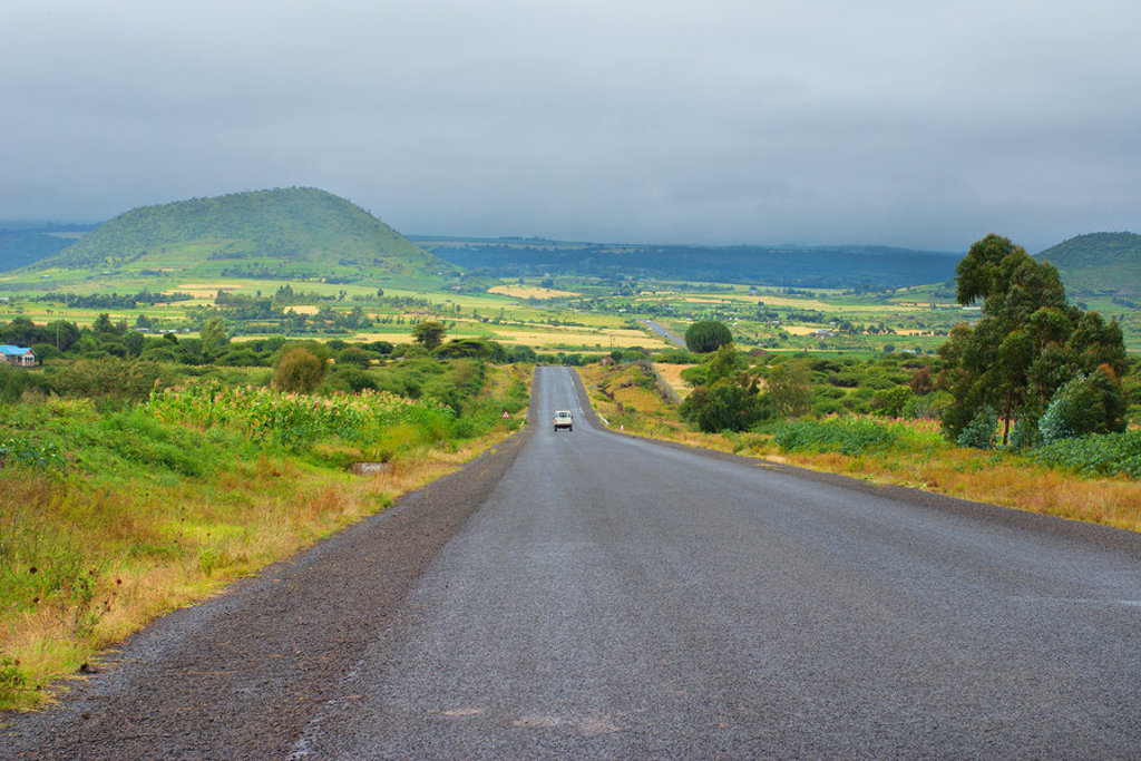 Lange weg door groen heuvellandschap tijdens groepsrondreis Kenia en Tanzania.