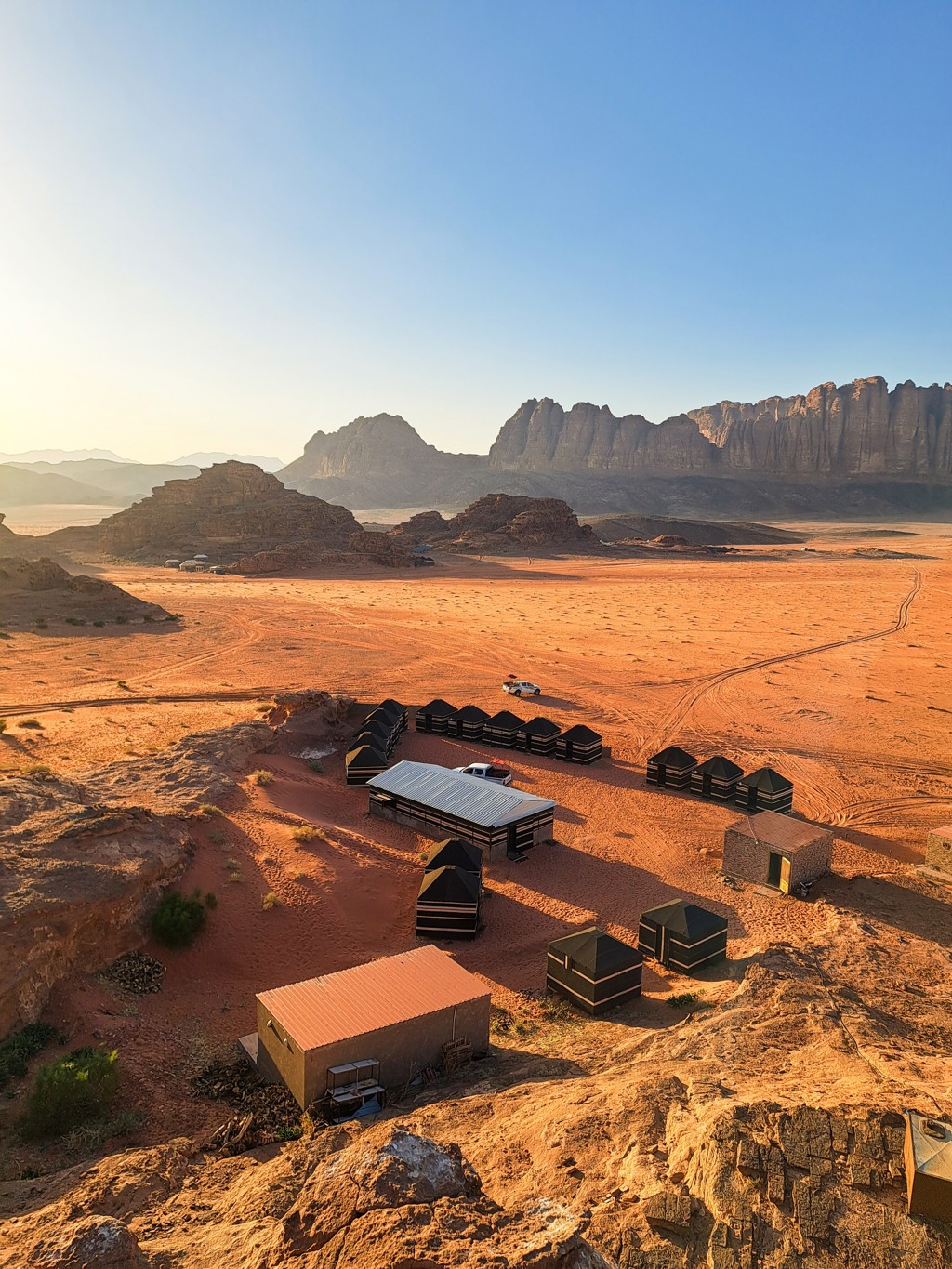 Woestijnkamp met tenten in Wadi Rum, Jordanië, met rotsformaties op de achtergrond.