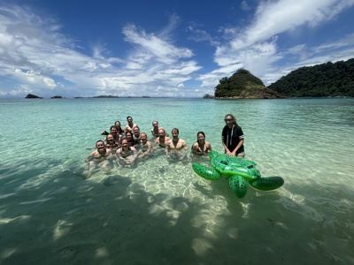 Groepsfoto van 22-35ers in helder zeewater bij een eilandstrand in Thailand tijdens de route Thailand, Laos & Cambodja.