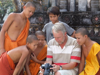 Toerist toont foto’s op camera aan jonge monniken bij een tempel in Laos tijdens de route Laos & Cambodja.