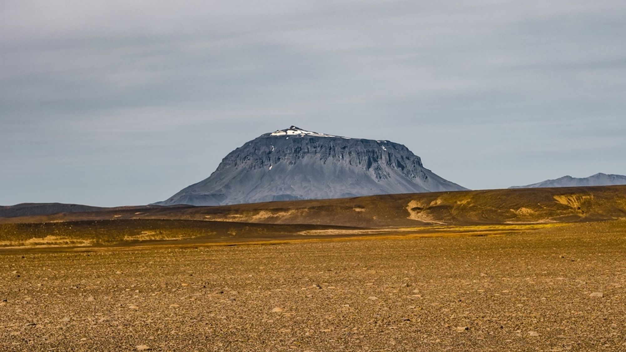 Tafelberg Herðubreið in de IJslandse hooglanden, met kale lavavlakte op de voorgrond.