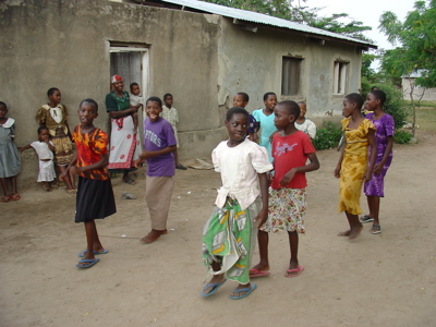 Kinderen dansen en spelen op een dorpsplein tijdens de Route Kenia en Tanzania.