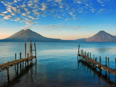 Houten steigers aan het Meer van Atitlán met vulkanen op de achtergrond, Route Ruta Maya.