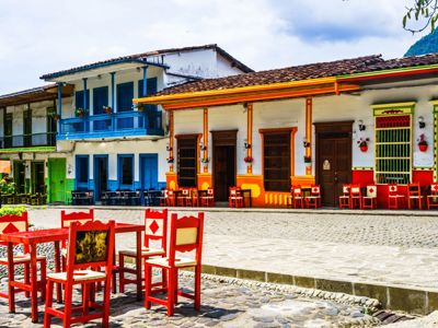 Kleurrijke gevels en terrasstoelen aan een plein in Salento, Colombia.