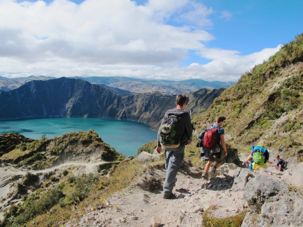 Wandelaars afdaling langs de krater van Quilotoa met uitzicht op het turkooizen kratermeer, Ecuador.