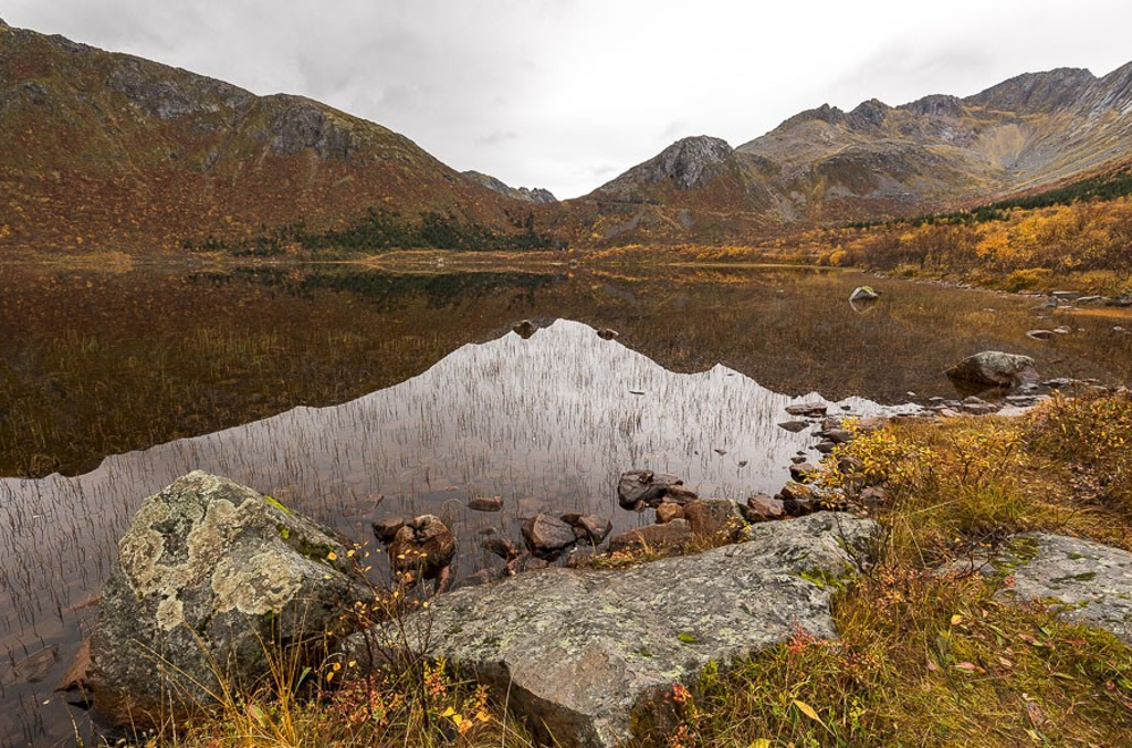 Berglandschap met spiegelend meer en herfstkleuren op de Lofoten in Noorwegen.