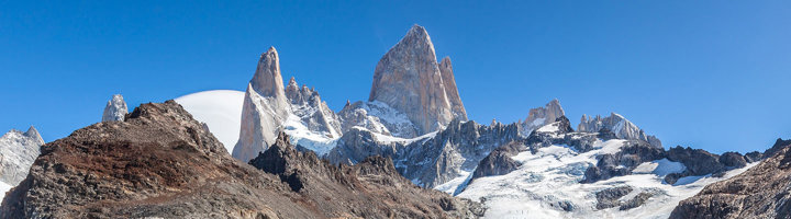 Bergtoppen van de Fitz Roy bij El Chaltén in Patagonië, met sneeuw en gletsjers onder een blauwe lucht.
