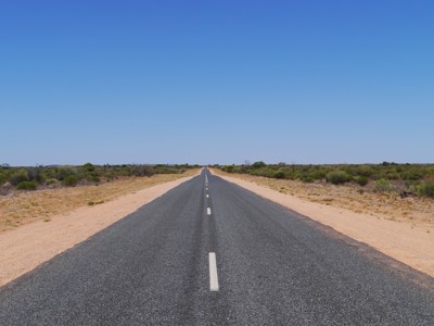Eindeloze rechte weg door de savanne op de route van Windhoek naar Victoria Falls.