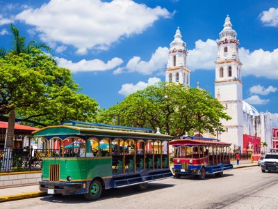 Kleurrijke toeristentrein op het plein bij de kathedraal van Valladolid, Route Mexico.