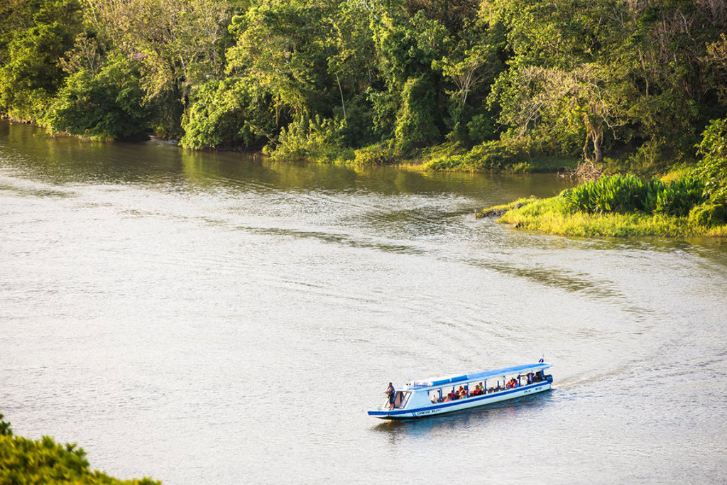Boottocht over een rivier langs dicht regenwoud tijdens groepsrondreis Nicaragua en Costa Rica.