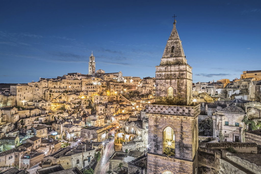 Avondzicht op de Sassi van Matera met verlichte huizen en kerktorens tijdens wandelvakantie Italië Puglia & Matera.
