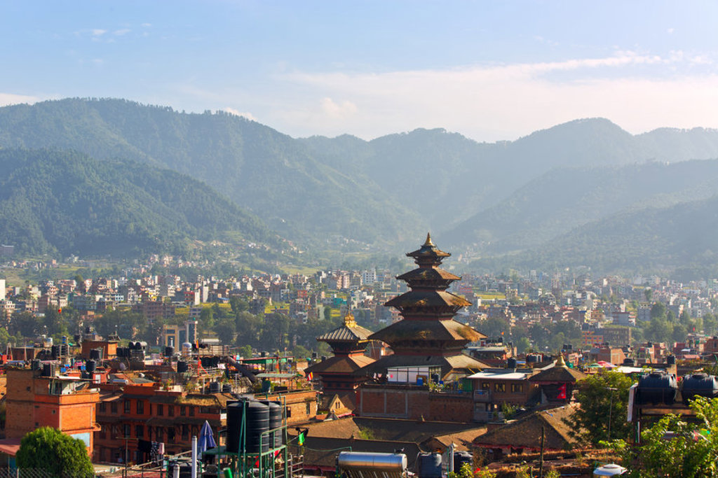 Uitzicht op Kathmandu met een pagode-tempel en groene bergen tijdens een 22-35ers reis Nepal.