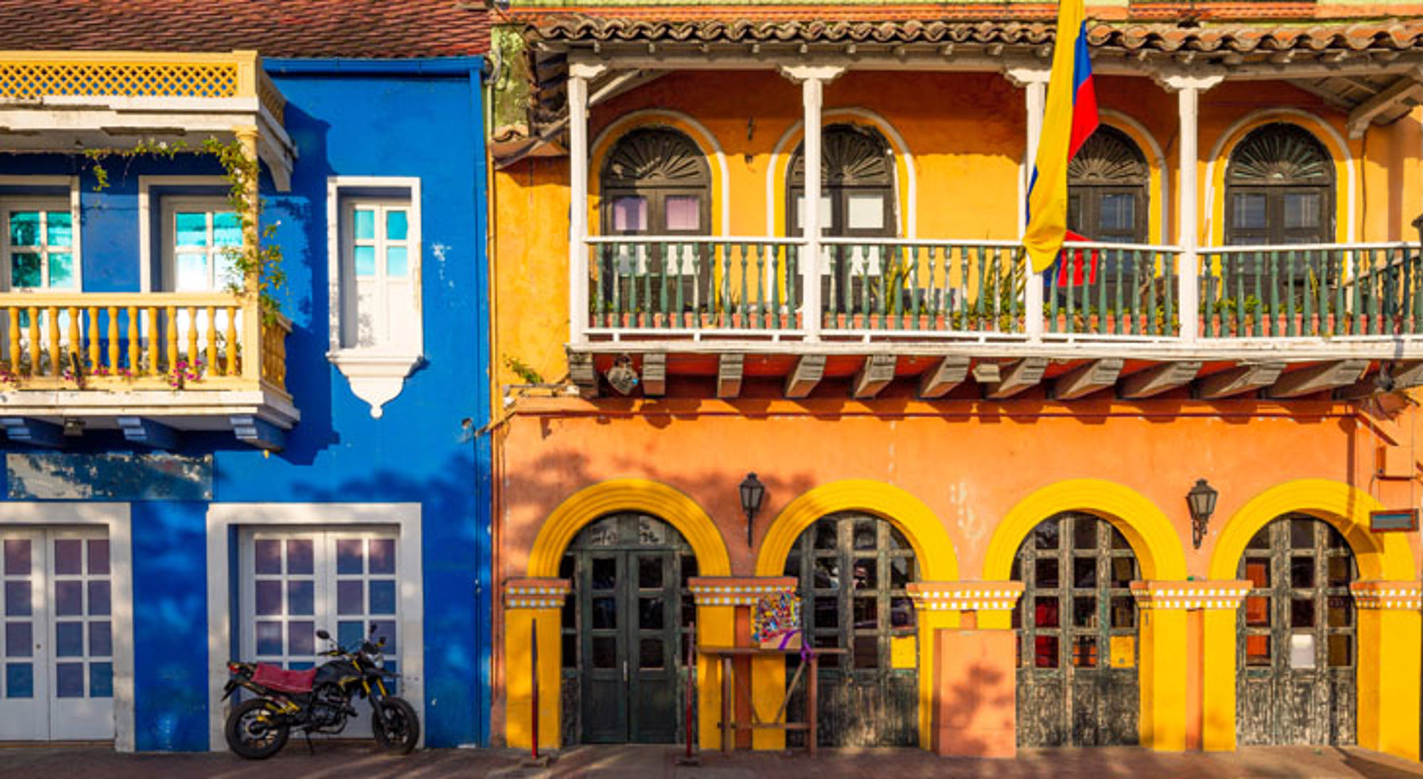 Kleurrijke gevels met balkon en Colombiaanse vlag in Cartagena, Colombia.