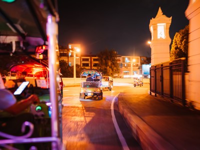 Tuktuks rijden ’s avonds door de straten van Bangkok tijdens de Route Thailand.