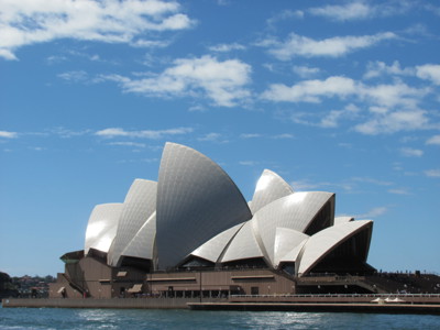 Sydney Opera House aan de haven van Sydney onder een blauwe lucht.