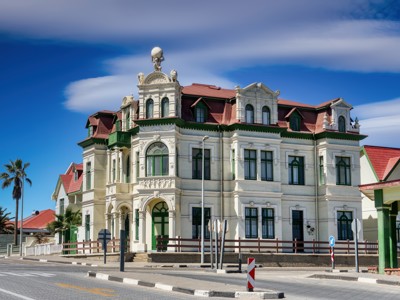 Historisch gebouw in Windhoek met rode daken en sierlijke gevel onder een blauwe lucht.