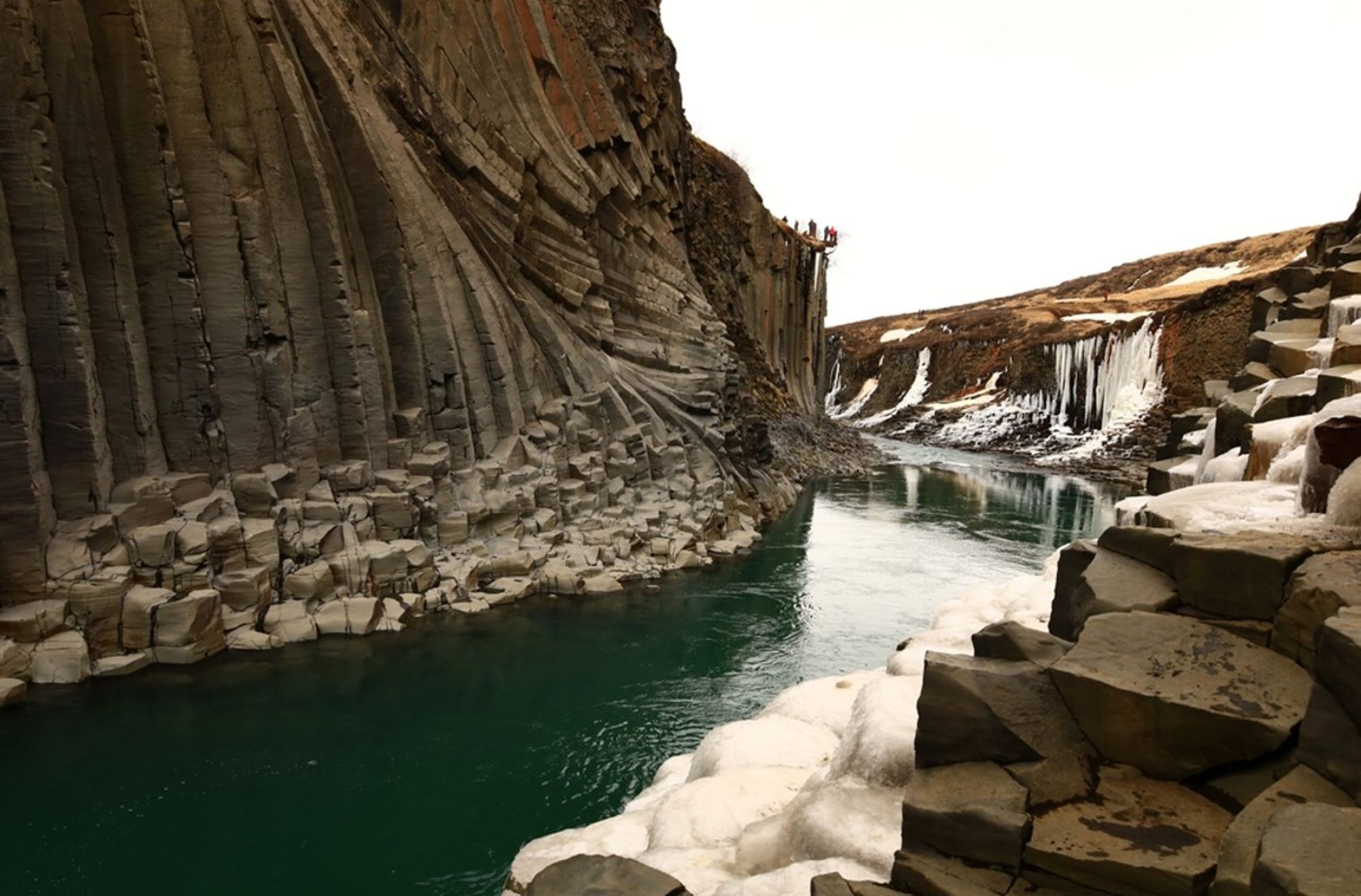Basaltkolommen in Studlagil-kloof met turkoois rivier en sneeuwresten, IJsland.