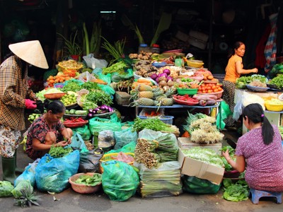 Groentemarkt in Vietnam met kramen vol verse groenten, kruiden en fruit tijdens de Route Vietnam.