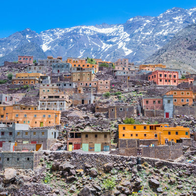 Berberdorp in het Atlasgebergte bij Mount Toubkal, Marokko, met besneeuwde bergtoppen op de achtergrond.
